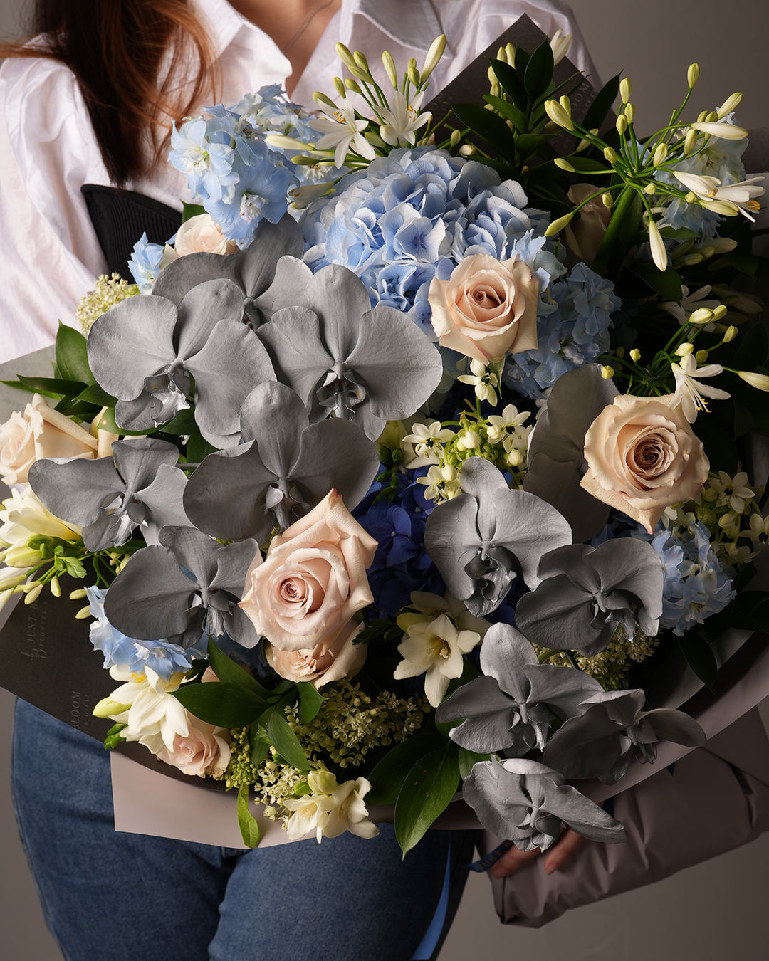 Close-up of Harmony floral arrangement with Dutch roses, orchids, hydrangeas – elegant flower bouquet HK