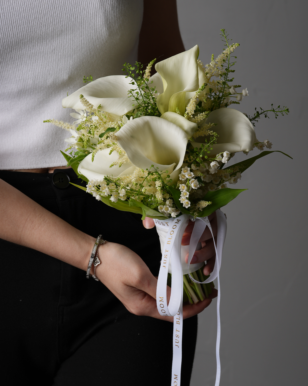 Finley wedding bouquet in white tones by Just Bloom shown with model in white top