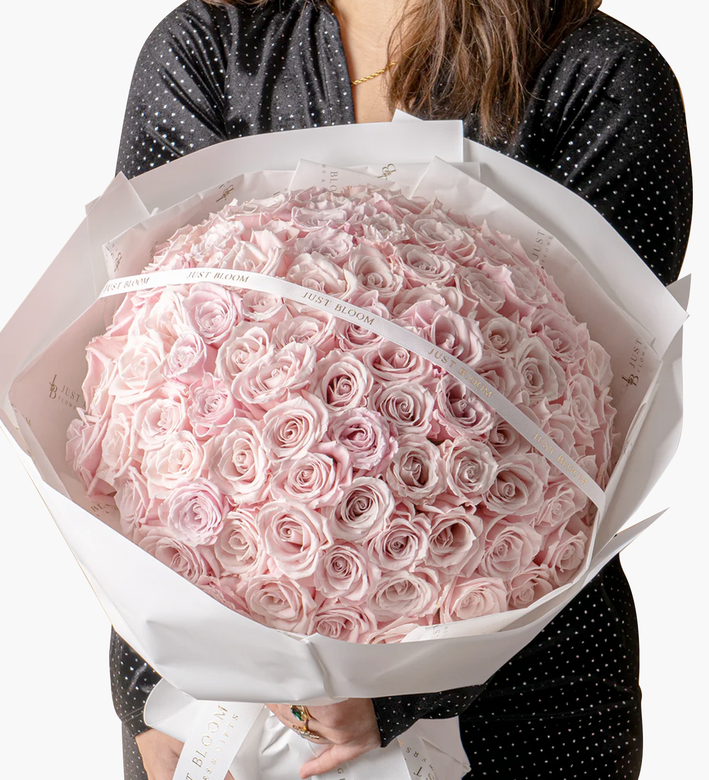 Woman in polka dot dress holding Lennon luxury pink rose bouquet showing full presentation