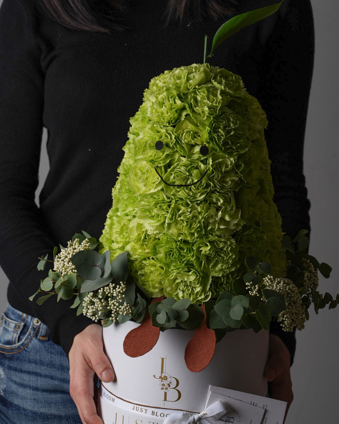 Little Pear creative pear-shaped carnation flower box held by woman in black sweater with white hatbox base