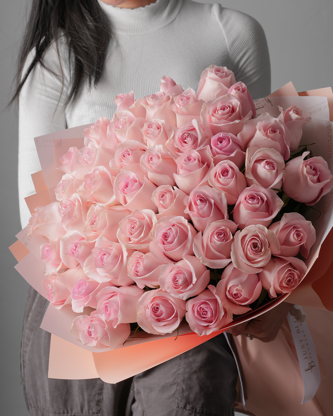 Close-up view of Marley soft pink rose bouquet wrapped in blush paper