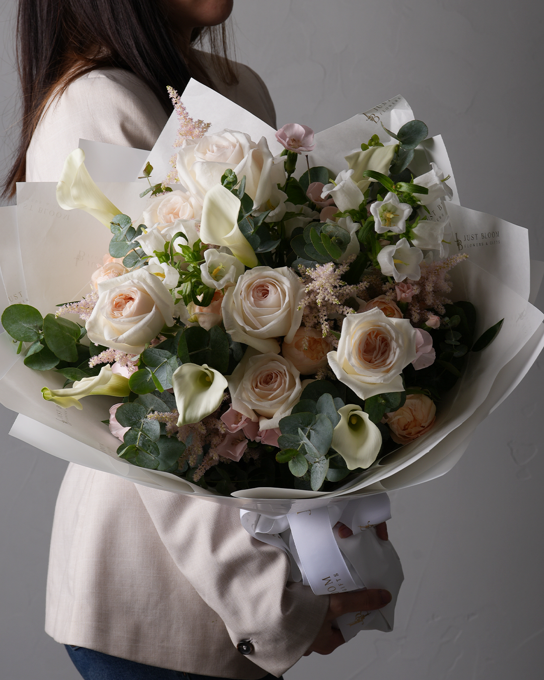 Melody bouquet with white and blush roses, calla lilies, and astilbes
