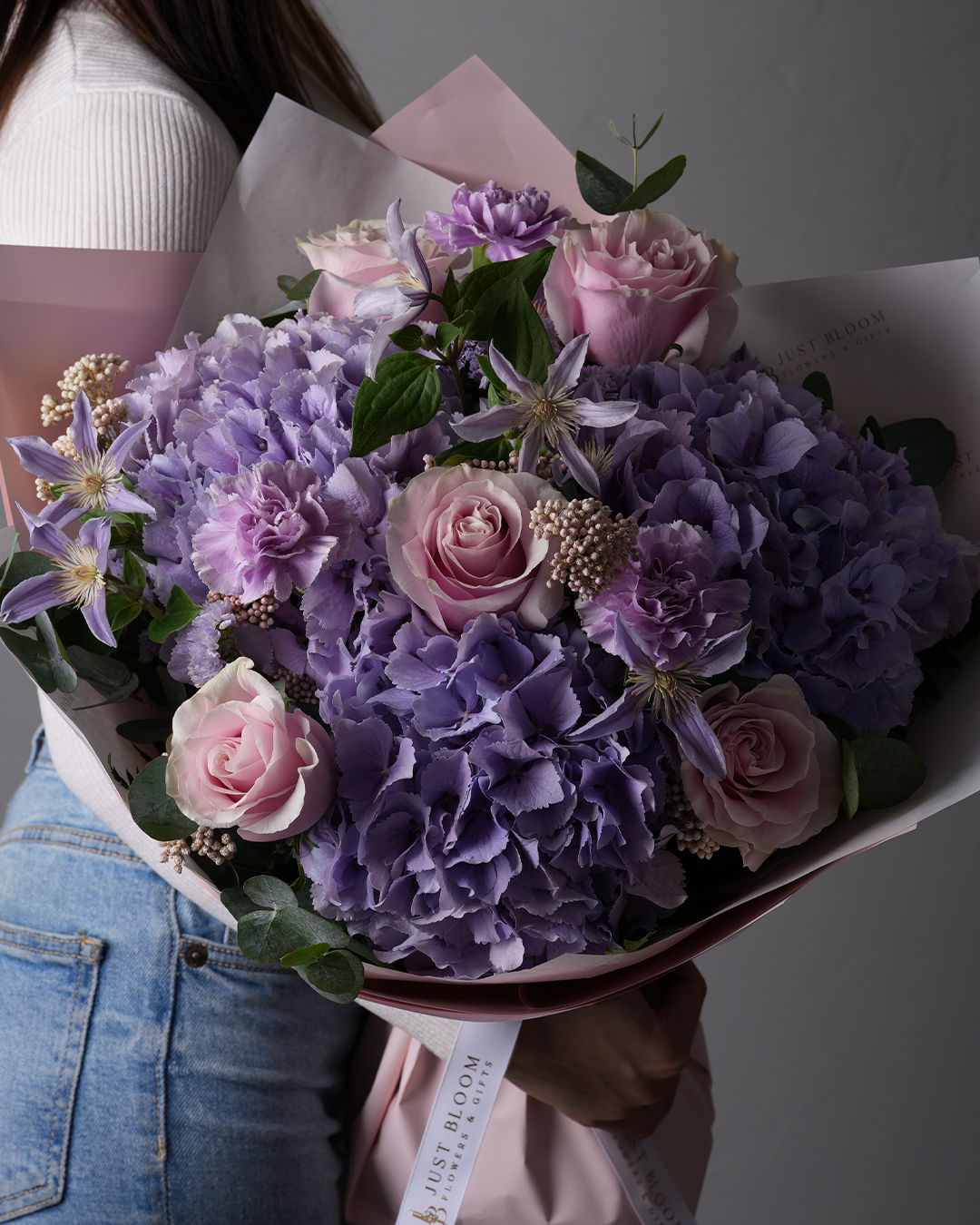 Side view of Peyton bouquet featuring purple hydrangeas, roses, and clematis