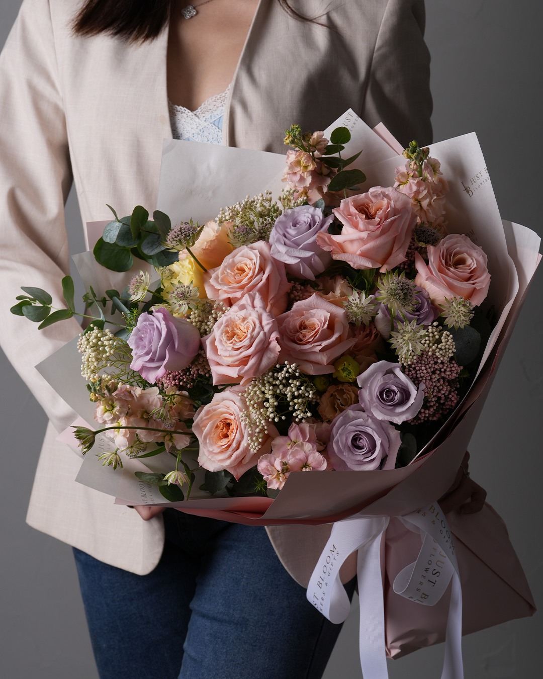 Raelynn bouquet with garden roses, lilac eustomas, rice flowers and stocks in soft pink and purple