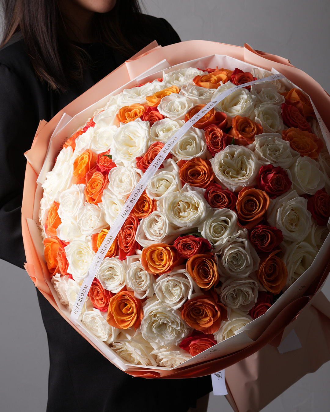 Rylee premium rose bouquet featuring orange, coral, and white roses in large round wrapping